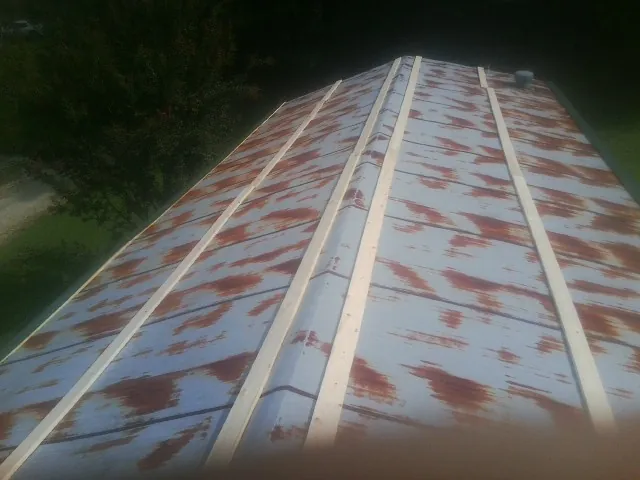 Rusted metal roof panels with new wood purlins before replacement — Storm Damage Roof Repair in Harper by Roofing Brothers