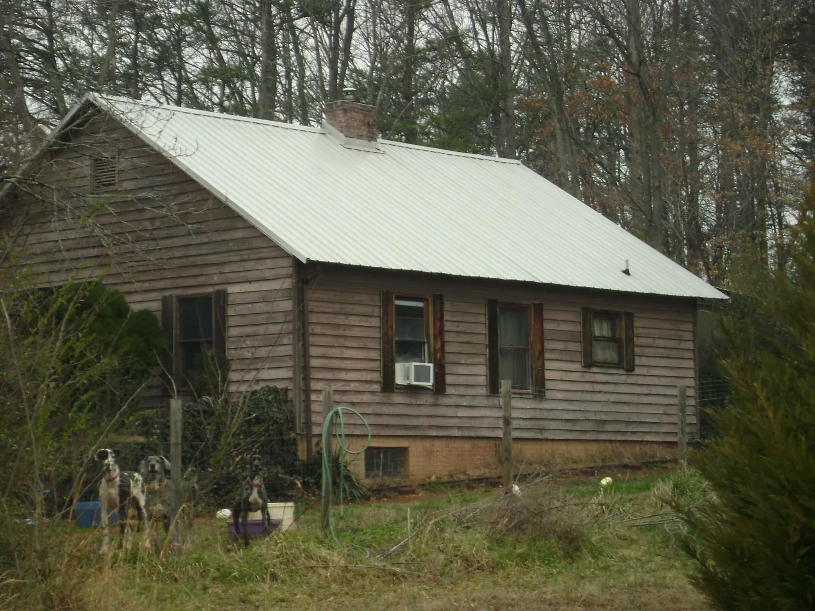 White metal roof on an old wood sided farmhouse, from a Metal Roof Installation job in Harper
